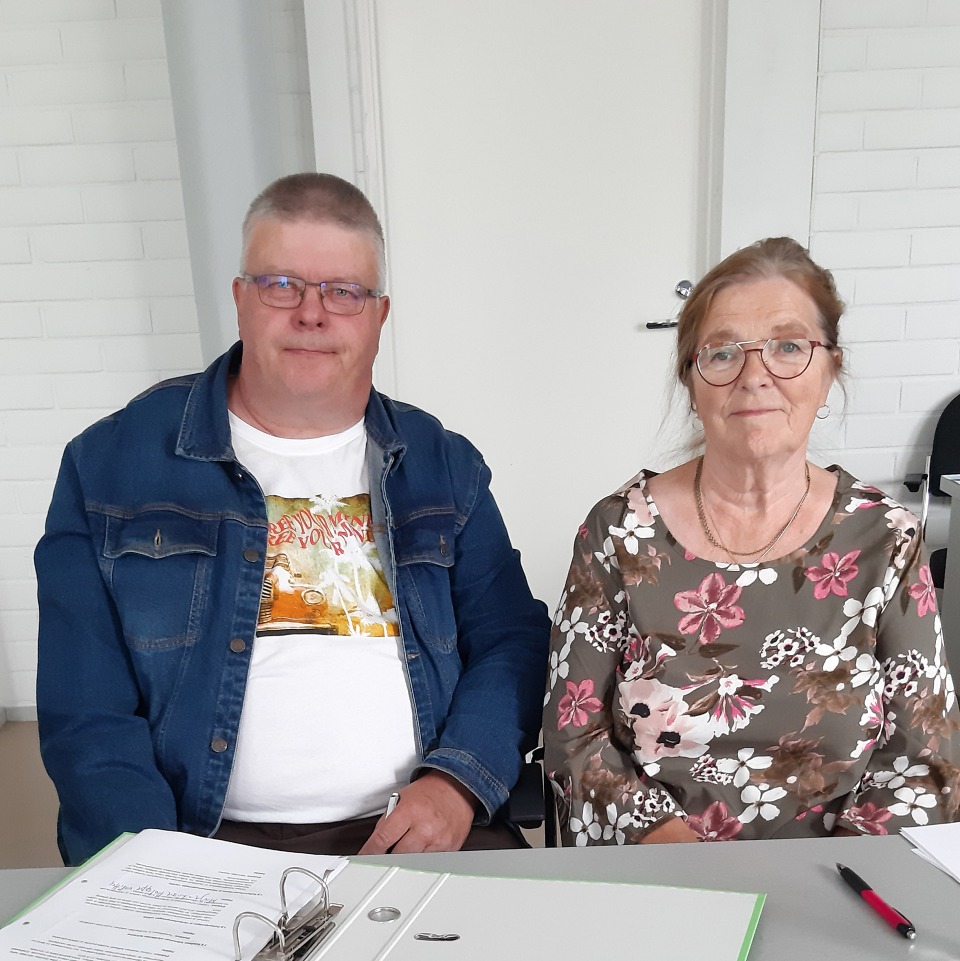 Kaksi henkilöä istuu pöydän äärellä, Suomussalmen vanhus- ja vammaisneuvoston puheenjohtajat 2023-25.